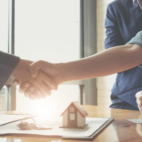 Real estate agents agree to buy a home and give keys to clients at their agency's offices. Concept agreement